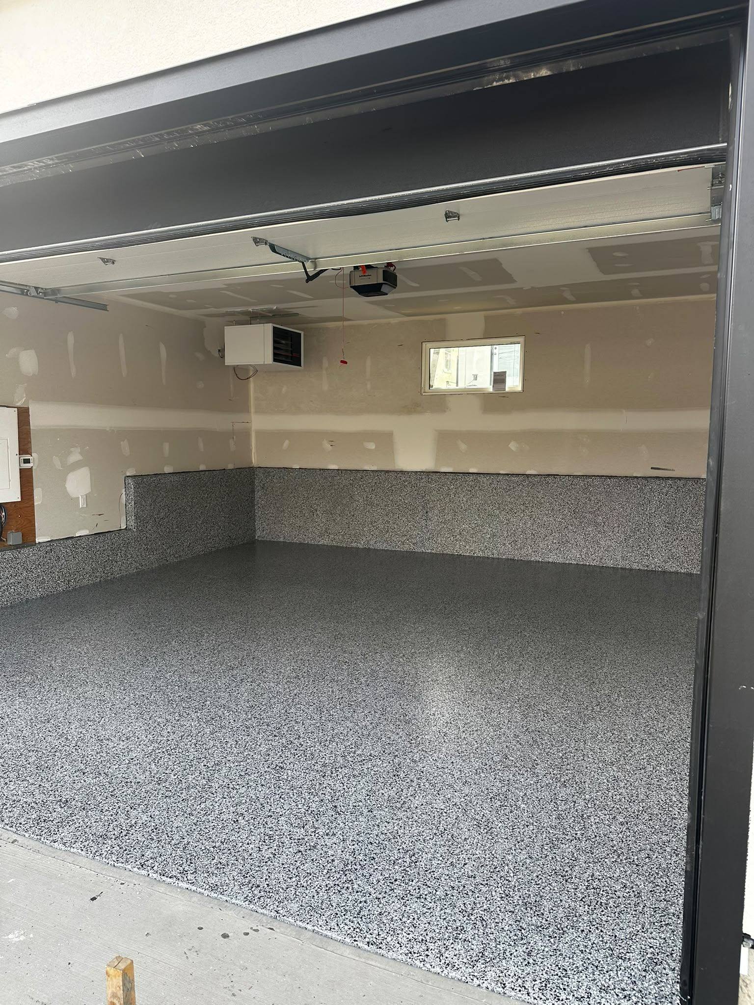 Residential garage with completed grey flake floor and matching cove base