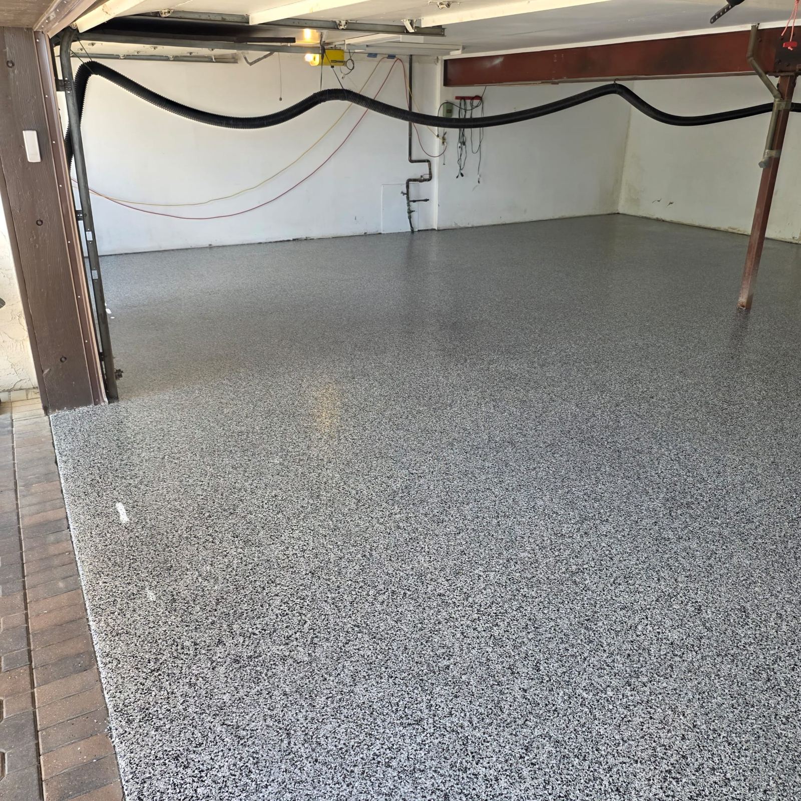 Grey flake epoxy garage floor with brick threshold